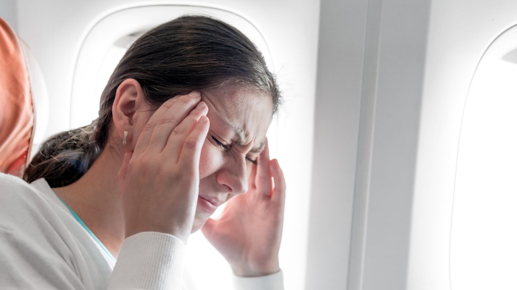 Portrait of a woman with a headache on an airplane